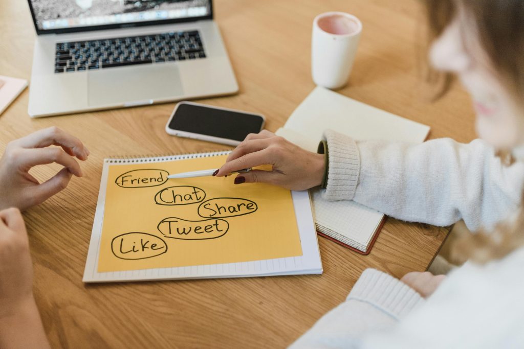 Best Small Business Marketing Company Jensen Beach Florida a Person Sitting at a Meeting Desk Looking at a Sheet of Paper That Says Like, Friend, Follow, Tweet, Share