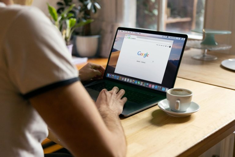 Best Google Business Profile Marketing Agency in Jensen Beach Florida a Woman Sitting at a Desk Working on a Laptop with Google on the Display