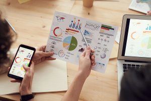 Best Small Business Marketing Services in Palm City Florida a Person Sitting at a Desk Looking at a Graph on a Paper