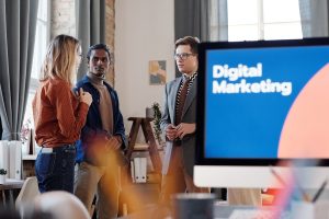 Best Small Business Marketing Services in Treasure Coast a Computer Screen That Says Digital Marketing with a Group of People Standing Together and Talking in the Background
