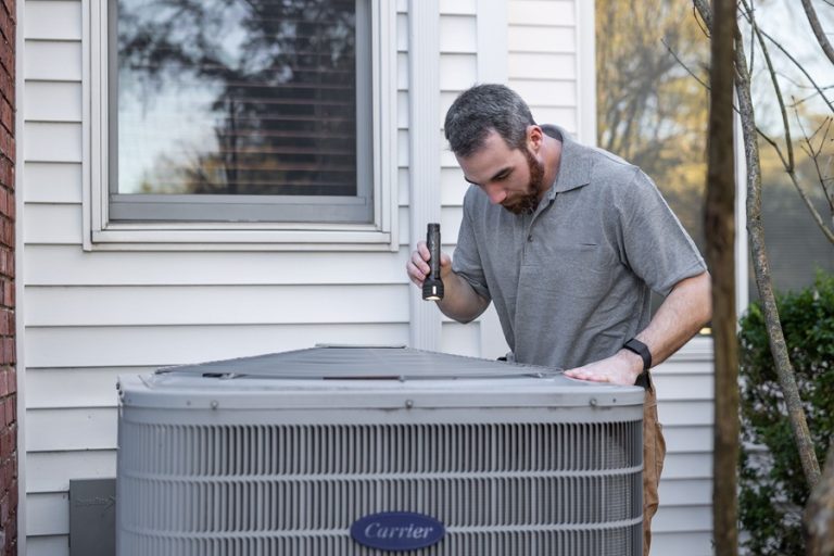 Best Marketing for HVAC Companies in Palm Beach County Florida a Man Inspecting an AC Unit Outside a Home