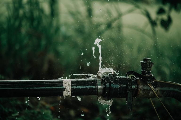 Marketing for Plumbers in Palm Beach County Florida Water Bursting Out of a Pipe with Grass in the Background