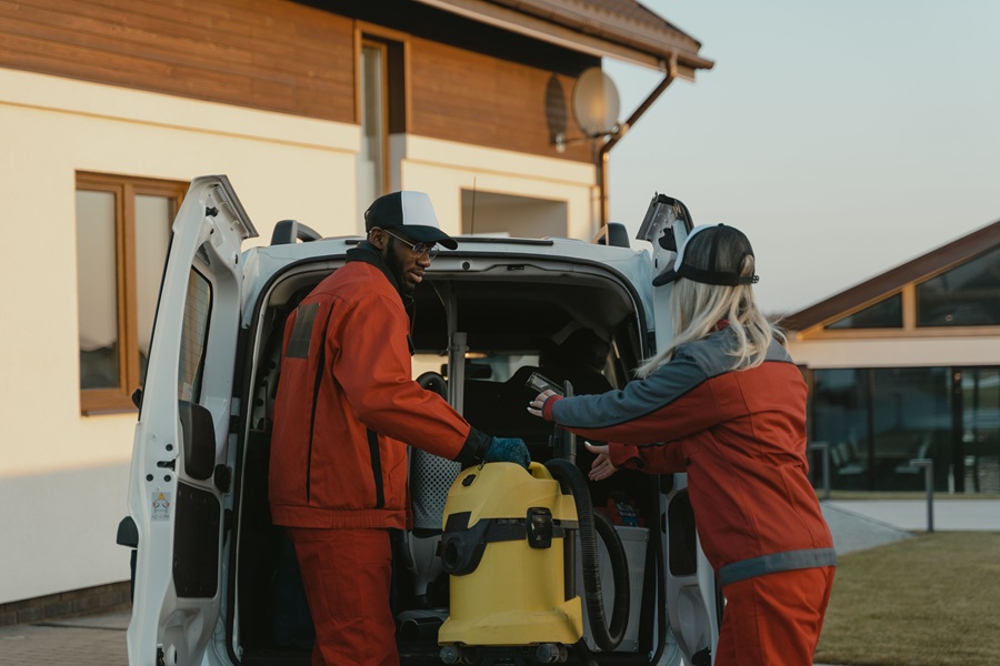SEO Marketing for Home Service Businesses in Palm City Florida Two People Dressed in Jumpsuits Pulling a Vacuum Out of a Van